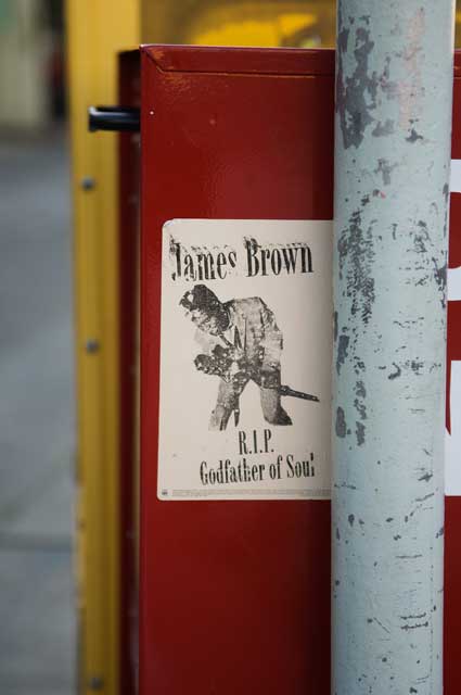 Graffiti sticker on a sidewalk newsbox on Grand Avenue in Oakland.